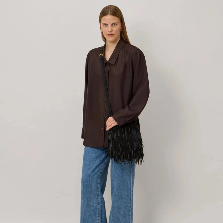 Mulberry crossbody taske i sort læder med frynser, båret af model med brun skjorte og jeans. Model 11442012