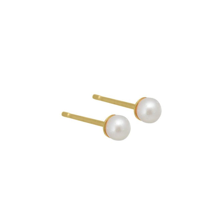 Aqua Dulce Lola Pearl Studs Vergoldet zeigt ein Set kleiner vergoldeter Ohrstecker mit weißen Perlen. Modell 3986-1