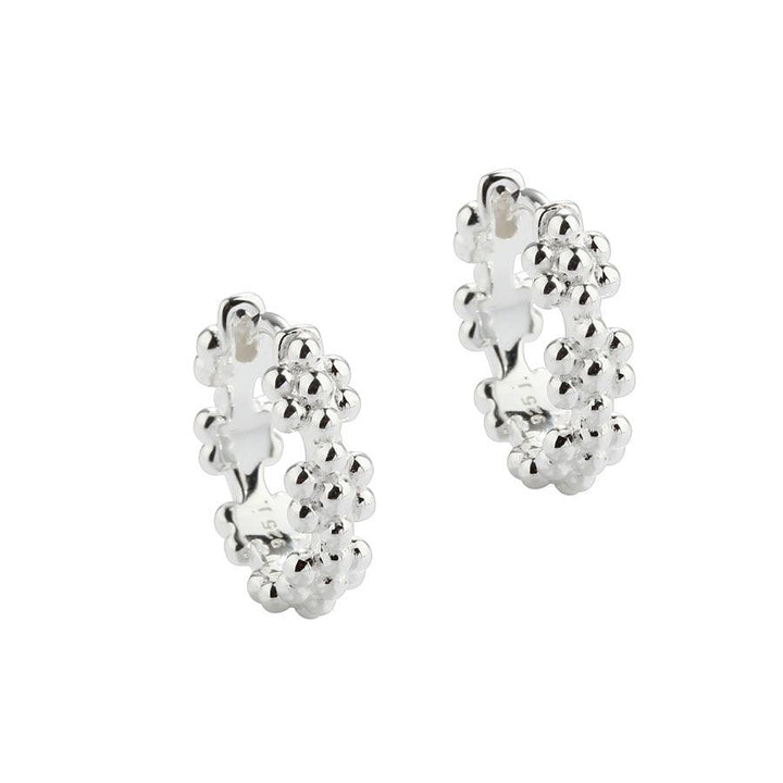 Aqua Dulce Lots of Flowers Creolen Silber 13 mm 5705–1 zeigt ein Paar silberne Creolen mit floralen Details. Modell 5705–1.