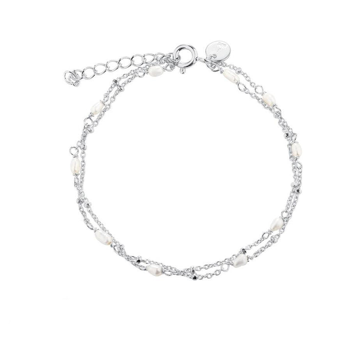 Aqua Dulce Rice Dot Double Armband mit doppelten Silberketten und kleinen weißen Perlen. Modell 5371-5371-1