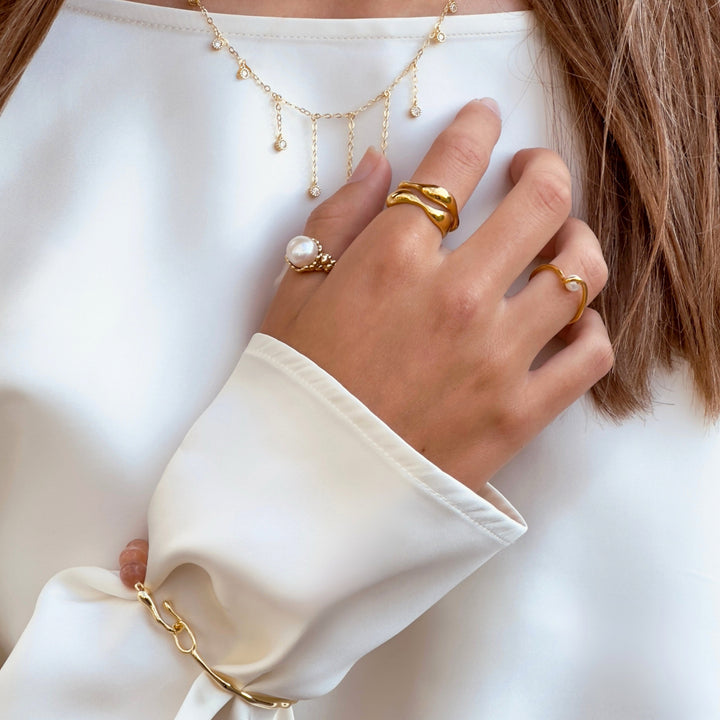 Vergoldeter Aqua Dulce Wave-Ring, auf der Hand gesehen mit anderen Ringen, elegantes und organisches Design. Modell 6626-001