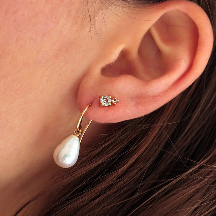 Carré-Bon-Bon-Ohrringe mit vergoldetem Blautopas im Ohr, funkelnden Steinen und elegantem Design. Modell FS4445BT-2