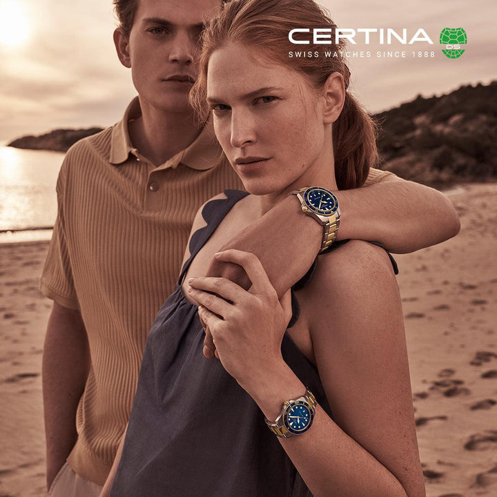 Certina DS Action, blaues Zifferblatt, PVD, 40 mm, Quarz C0484102204100, abgebildet auf der Hand einer Frau, Strandhintergrund, Modell C0484102204100.