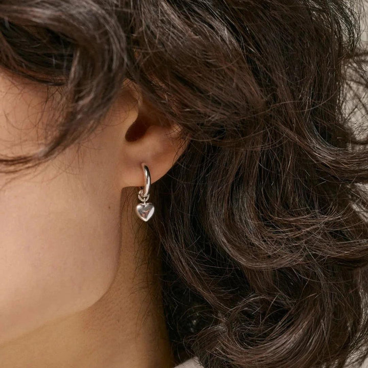 Enamel Abgebildet sind Amore Solv Creolen am Ohr, silberner Herzanhänger-Ohrring. Modell e376s-e376s-2.