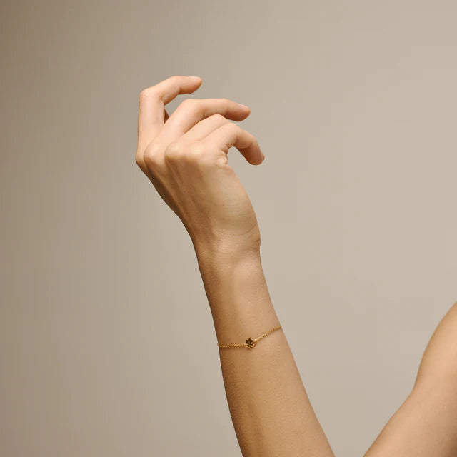 enamel-Vierblättriges Kleeblatt-Armband aus vergoldetem Sol wird am Handgelenk getragen, dünnes Kettenarmband in Goldoptik mit kleinem Kleeblatt-Detail. Modell b148gm-2