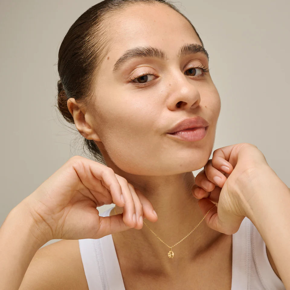 Enamel Vierblättriges Kleeblatt-Halskette aus vergoldetem Silber, getragen von einer Frau mit weißem Oberteil, Modell n138gm-1