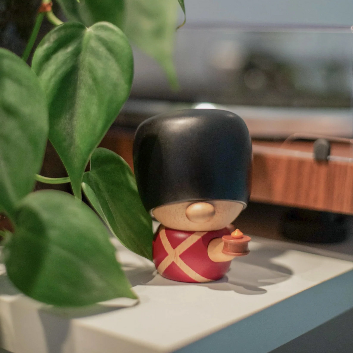 Fablewood HC Andersens Fyrtøjet-8005-1 Holzfigur einer Wache in roter Uniform und schwarzem Bärenfellhut auf einem Regal bei Green Plant. Modell 8005-1