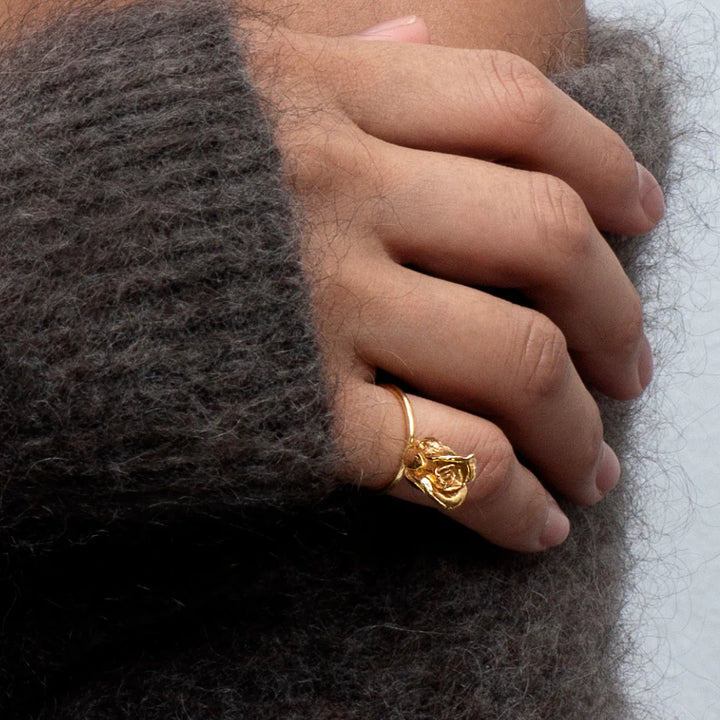 Flora Danica Auf der Hand erscheint ein vergoldeter Rose Statement Ring, ein detaillierter Roségoldring. Modell ros-ri-g-001