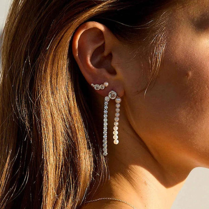 Hultquist Copenhagen Harper Croissant-Silberohrring am Ohr mit glänzender Oberfläche im Sonnenlicht. Modell S08607S-2