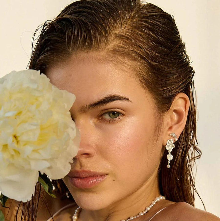 Hultquist Copenhagen Lainey Grande-Silberohrringe, getragen vom Model mit nassem Haar und Blume. Modell S08609S-2