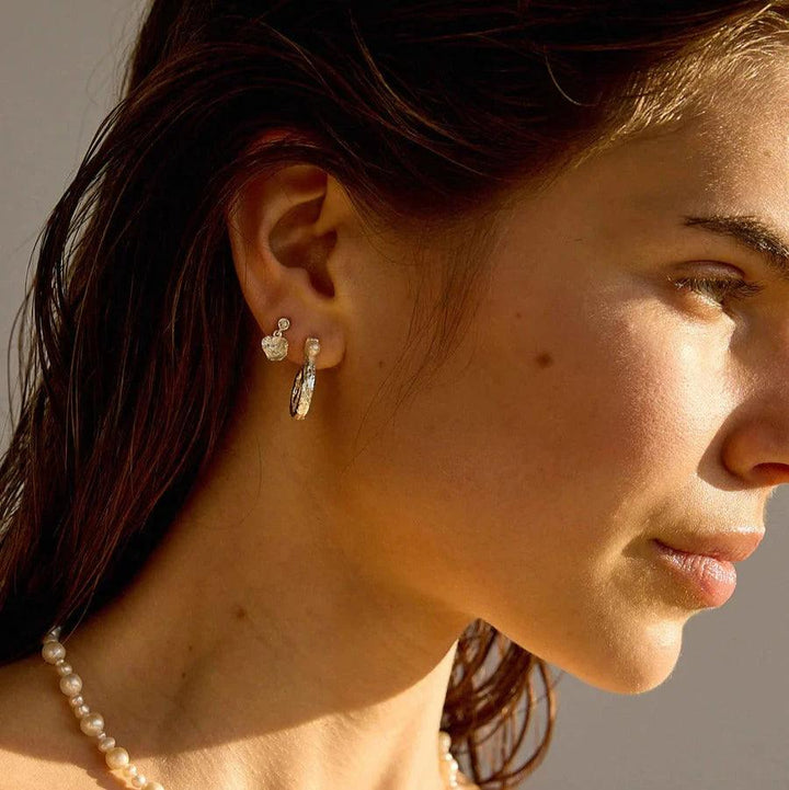 Hultquist Copenhagen Silberne Ohrstecker von Lainey Petite am Modell mit Perlenkette im Sonnenlicht. Modell S08610S-2