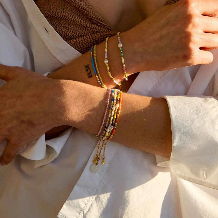 Hultquist Copenhagen Paisley-Perlenarmband mit farbigen Perlen und Perlendetails am Arm der Frau im Sonnenlicht. Modell S08619G-2