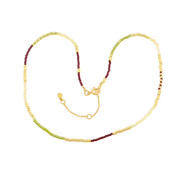 Hultquist Lucky-Halskette mit Perlen in Gold, Grün und Burgunderrot auf weißem Hintergrund. Modell S08637G-1.