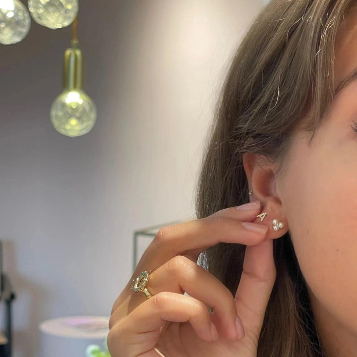 Der Jeberg Jewellery Cordelia Triple Pearl Stud wird hier im Ohr einer Frau getragen, mit drei weißen Perlen. Modell 52715-2
