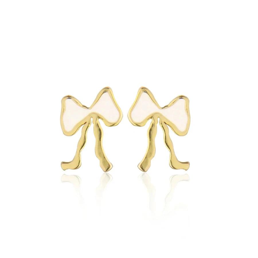 Jeberg Petite Bow White Stud Bow Earring zeigt ein Paar kleine gold- und weißfarbene Schleifenohrringe. Modell 52815-1