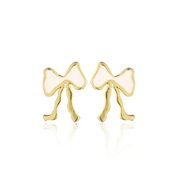 Jeberg Petite Bow White Stud Bow Earring zeigt ein Paar kleine gold- und weißfarbene Schleifenohrringe. Modell 52815-1