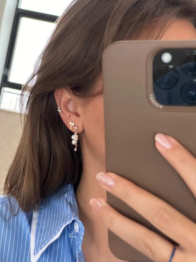 Jeberg Petite Bow weiße Ohrstecker werden im Ohr getragen, elegantes Design mit Perlendetails. Modell 52815-2