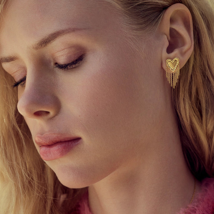 maanesten-giulietta-gold-platted-heart-earrings zeigen elegante goldene herzförmige Ohrstecker mit Kettendetails. Modell 10052a