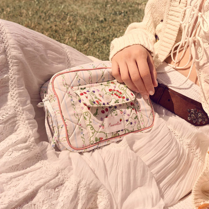 Die Maanesten Reva Bag Summer Stripes Blue wird hier in gesteppter Baumwolle mit Blumenmuster gezeigt, getragen auf einem weißen Kleid. Modell 4131-1