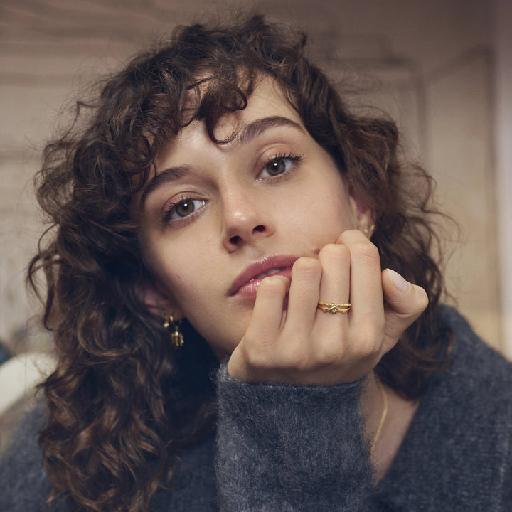 Maanesten Ria vergoldeter Ring erscheint an der Hand einer Frau, wellenförmiges Design in Goldoptik, Modell 4873a-001