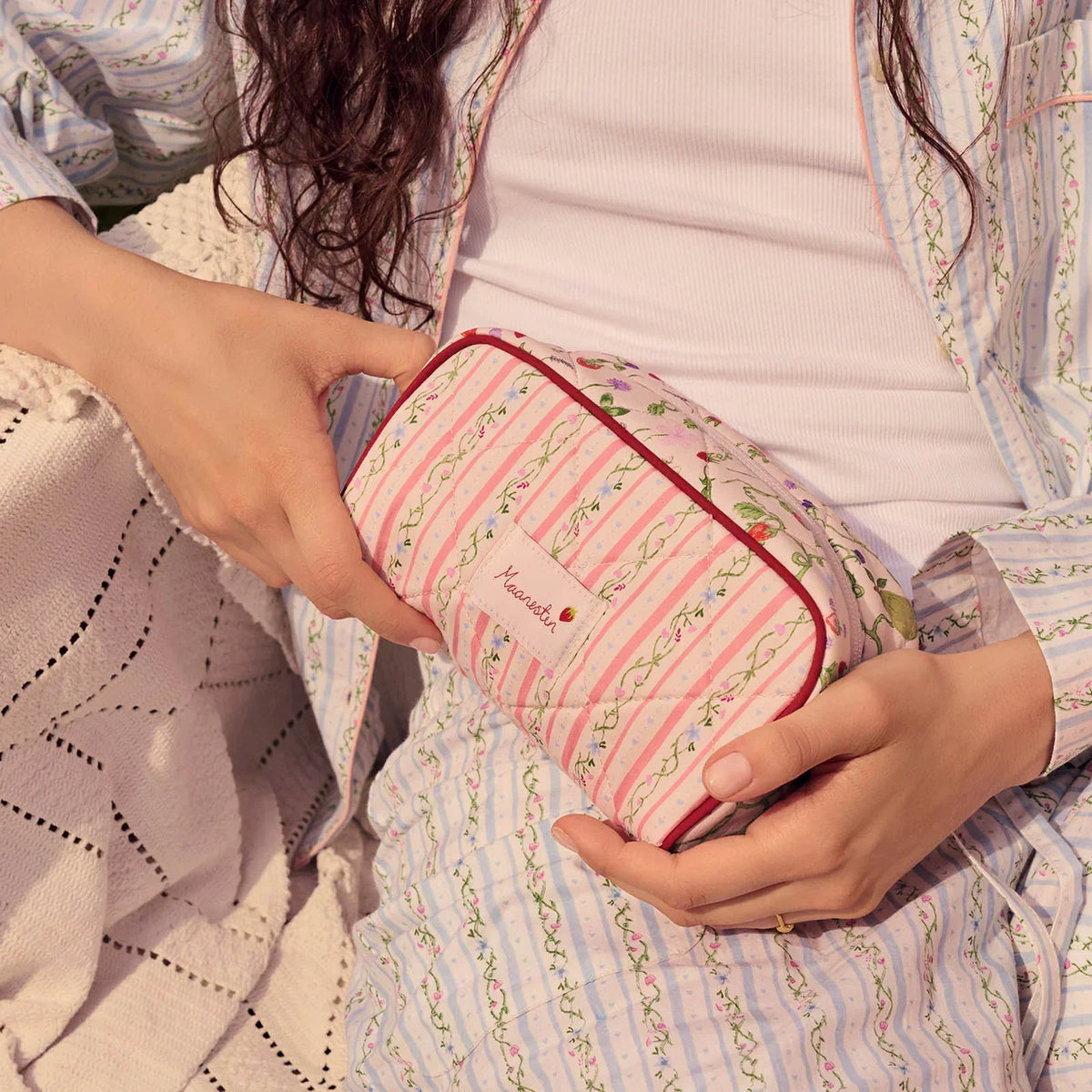Moonstone-Stardust-Bag-Summer-Stripes-Peach mit rosa und grün gestreiften Blumenmustern wird auf dem Schoß gehalten. Modell 4114 – Einheitsgröße