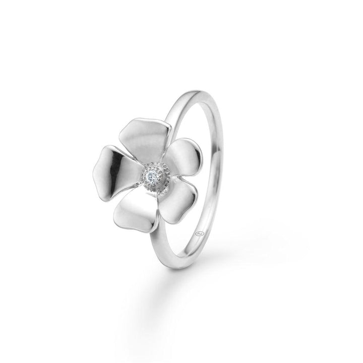 Mads Z Fleur Flower Silver Ring with Topaz zeigt einen eleganten Blumenring aus Silber mit klarem Topas in der Mitte. Modell 2146106-001.