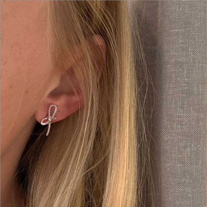 Mads Z Miss Butterfly Schleifenohrringe in Silber mit weißem Topas am Ohr. Modell 2116003-2