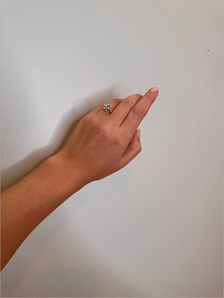 Mads Z Silver Rosalie Ring mit kleiner Rose wird am Finger getragen, eleganter Silberring im Rosendesign. Modell 2140156-001
