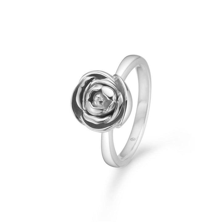Mads Z Silber Rosalie Ring M mittelrosa zeigt einen eleganten Silberring mit detailliertem Blumenmuster. Modell 2140157-001