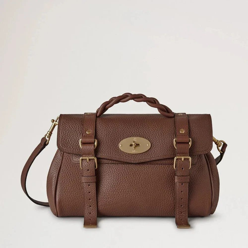 Mulberry Alexa Heavy Grain Bright Oak zeigt eine braune Ledertasche mit geflochtenem Griff und goldenen Details. Modell HH6746/736G222.