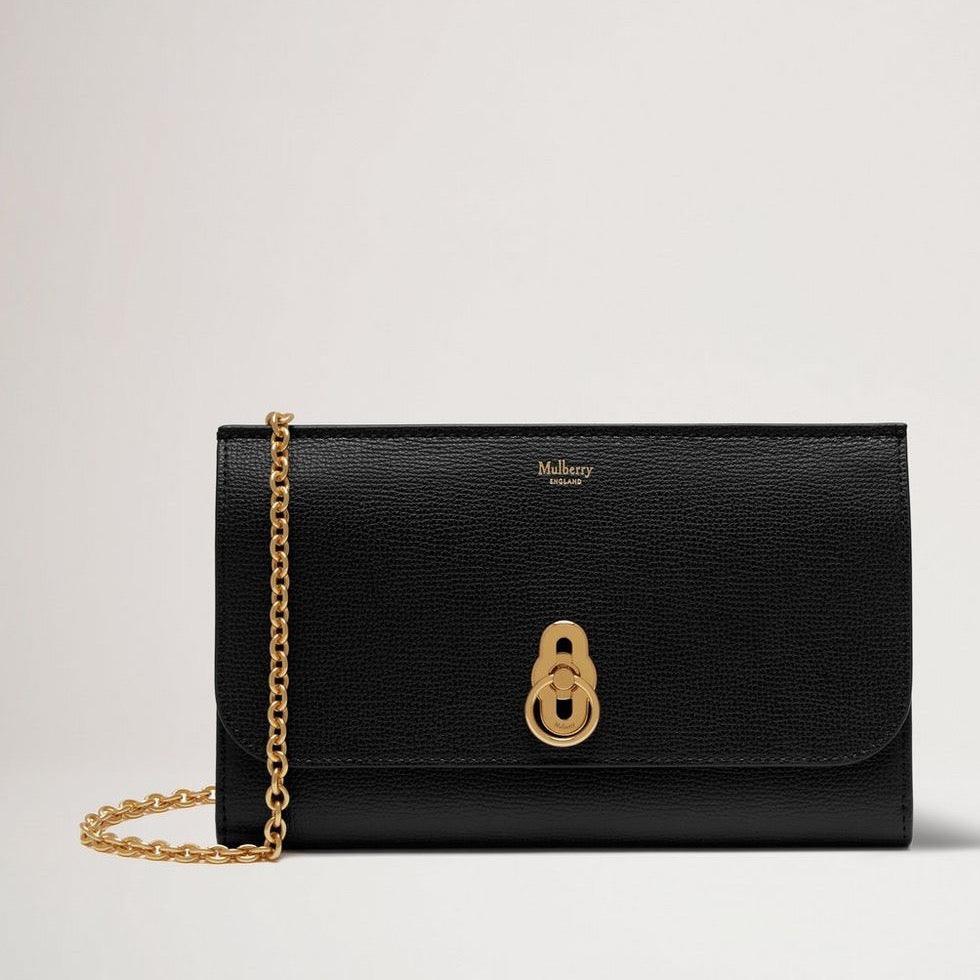 Mulberry Die Amberley Clutch Small Classic Grain Black ist eine elegante Clutch aus schwarzem Leder mit goldener Kette und charakteristischem Verschluss. Modell RL6090205A100.