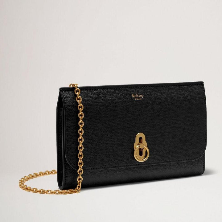 Mulberry Amberley Clutch Small Classic Grain Black zeigt eine elegante schwarze Clutch aus geprägtem Leder mit goldener Kette und Verschluss, Modell rl6090205a100.
