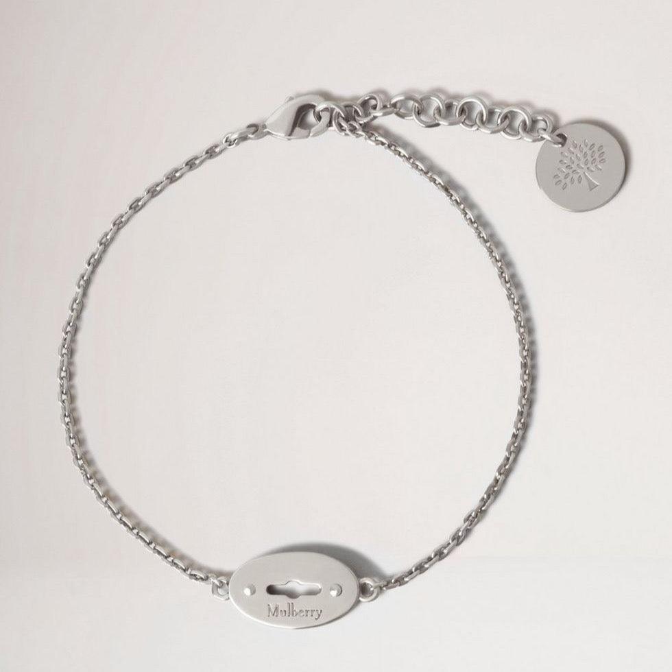 Mulberry Bayswater Armband Sterling Silber zeigt ein elegantes, silberfarbenes Armband mit Logo-Anhänger. Modell qb2397000d130-001-1