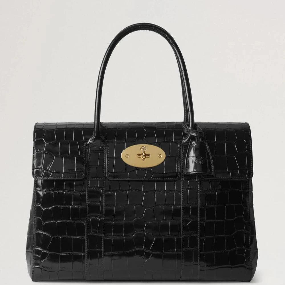Mulberry Bayswater Croc Black zeigt eine elegante schwarze Handtasche aus Leder mit Krokodilprägung und goldenem Verschluss. Modell HH9589641A100