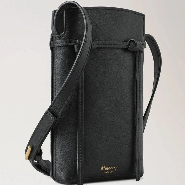 Mulberry Die Clovelly Phone Pouch Refined Flat Calf Black präsentiert eine elegante schwarze Handytasche aus glattem Leder mit verstellbarem Riemen. Modell RL8072635A100.
