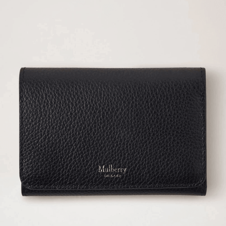 Mulberry Continental Trifold Card Holder schwarz aus schwarzem geprägtem Leder, von vorne gesehen in einer Studioumgebung. Modell rl6824205a100