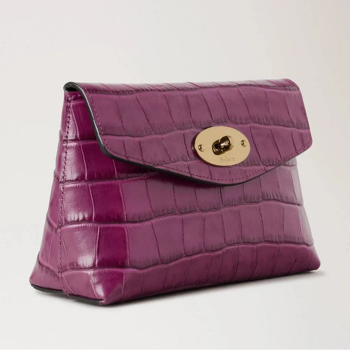 Mulberry Darley Kosmetiktasche Orchid Bloom Shiny Small Croc zeigt eine kleine Kosmetiktasche aus glänzendem lila Leder mit Krokodilprägung und goldenem Verschluss. Modell RL8187641J512.