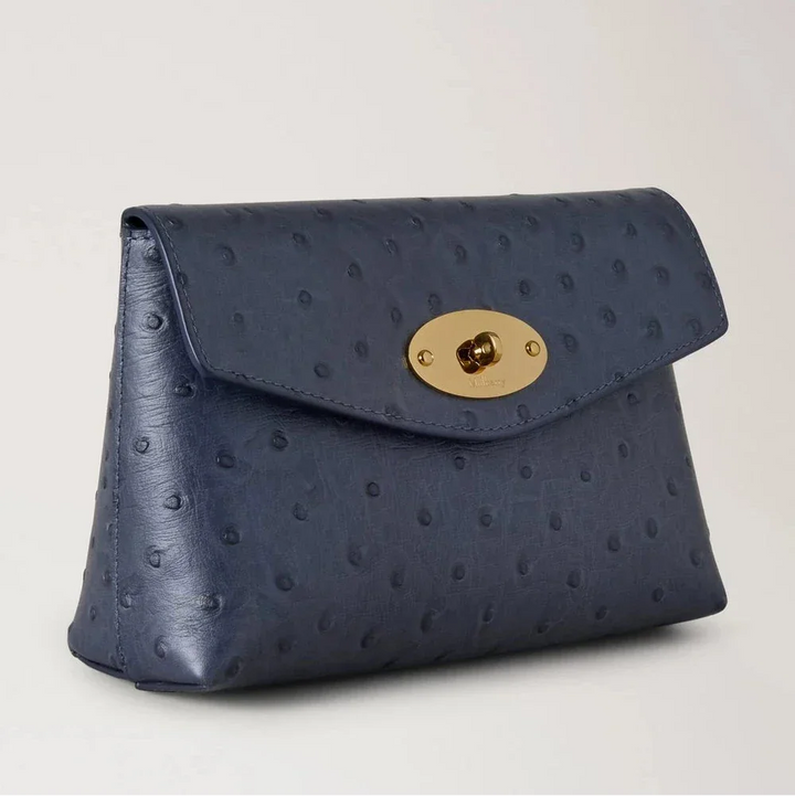 Mulberry Darley Cosmetic Pouch Ostrich Stormy Blue zeigt eine blaue Kosmetiktasche aus geprägtem Leder mit einer goldfarbenen Schnalle. Modell RL8933738U918.