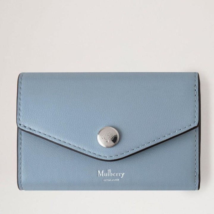 Mulberry Das gefaltete Multicard Wallet Poplin Blue zeigt ein hellblaues Lederportemonnaie mit silbernem Druckknopf, Modell RL7841587U804.