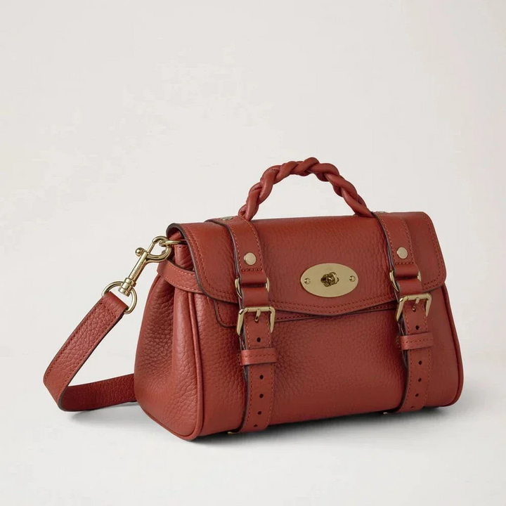 Mulberry Mini Alexa Heavy Grain Rust zeigt eine kleine, rostfarbene Ledertasche mit geflochtenem Griff und goldfarbenen Details. Modell RL6595736L190