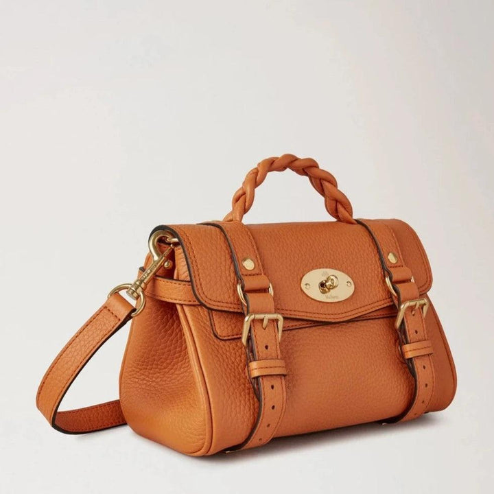 Mulberry Der Mini Alexa Heavy Grain Sunset wird in schwerem orangefarbenem Leder mit geflochtenem Griff und goldenen Details gezeigt. Modell RL6595736N691.