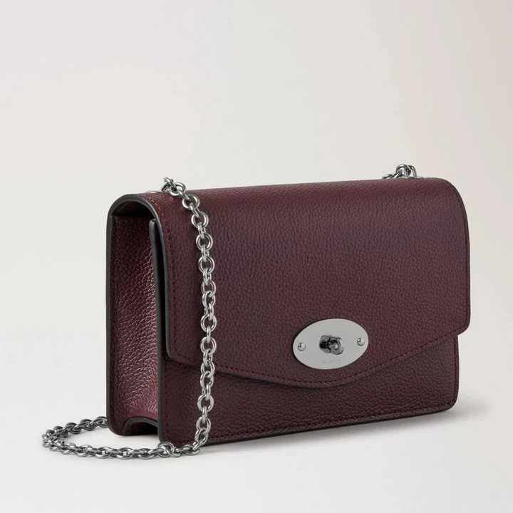 Mulberry Klein Darley Small Classic Grain Black Cherry zeigt eine kleine Umhängetasche aus dunkelrotem Leder mit silbernem Kettenriemen und Verschluss. Modell RL7791/205K560
