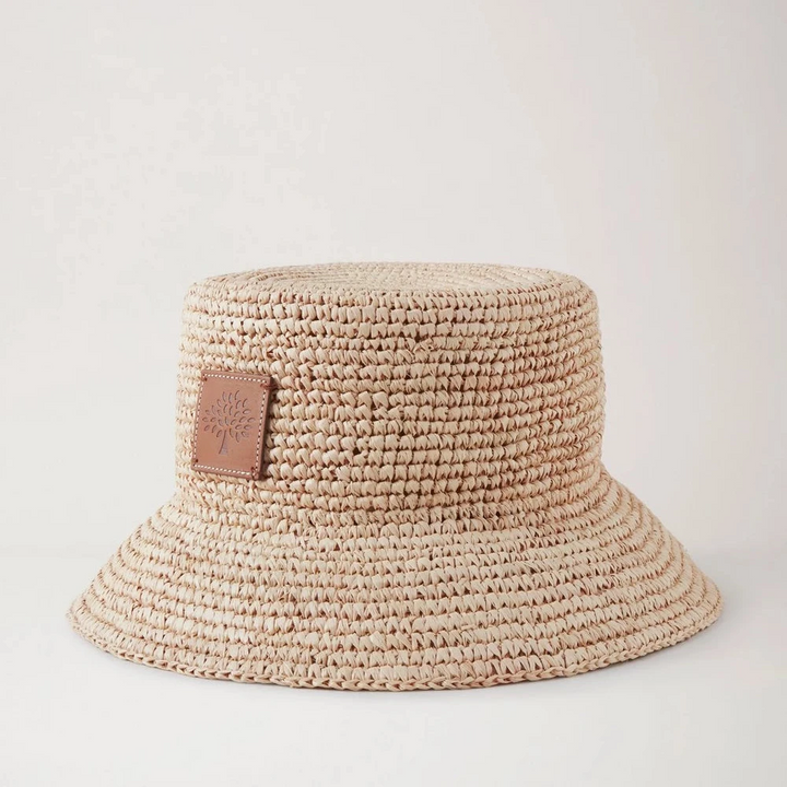 Mulberry Der Summer Raffia Bucket Hat zeigt einen hellen, geflochtenen Raffia-Sommerhut mit Lederaufnäher. Modell VH4097807H120.
