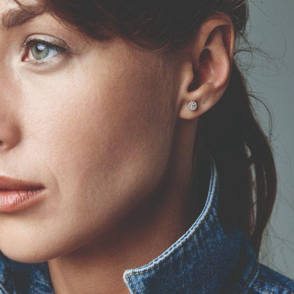 Nuran Cordelia Diamant-Ohrstecker aus 14-karätigem Gold, gesehen an einer Frau, rundes Modell mit dezentem Funkeln, Modell o2136-022rg-2.