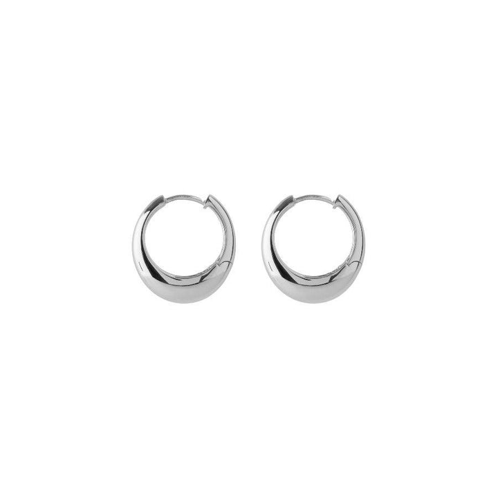 Pernille Corydon Globe Huggies in Silber, stilvolle und glänzende Creolen auf weißem Hintergrund. Modell E-401-S.