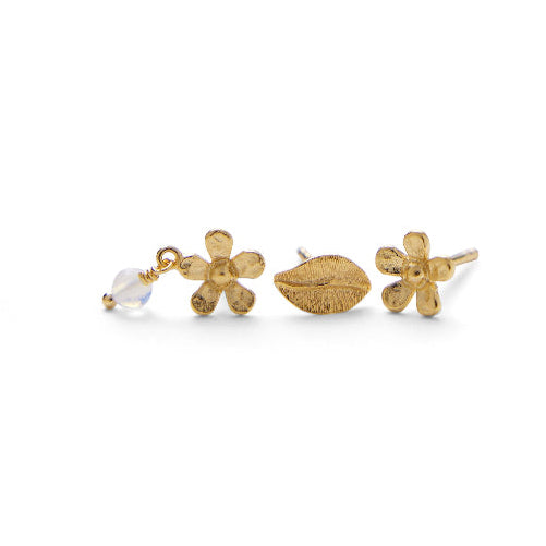 Die vergoldete Pernille Corydon Meadow Earring Box zeigt drei Ohrringe: zwei Blumen mit mattem Gold und einen mit Steinen und einem Blattmotiv. Modell C-121-GP