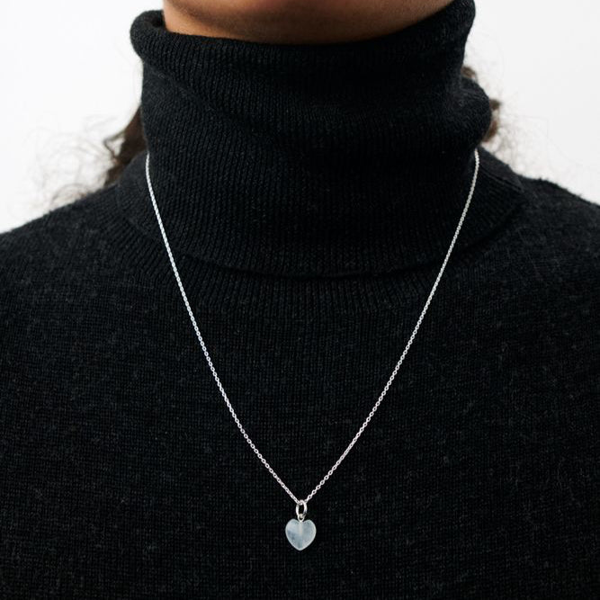 Pernille Corydon Ocean Love-Anhänger in Silber, abgebildet am Modell mit schwarzem Rollkragenpullover. Modell967S2