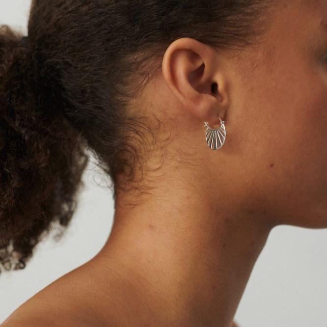 Pernille Corydon Kleine silberne Kreolen in Misty Light, abgebildet auf dem Ohr in neutralem Licht, Modell e-613-s-1