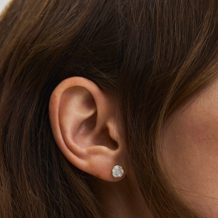 Pernille Corydon Small Rose Ohrstecker aus Silber, runder glänzender Ohrring am Ohr, Modell E-535-s