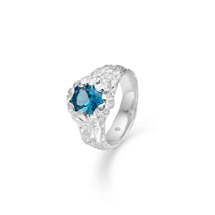 Der Studio Z Forest Ring präsentiert einen silberfarbenen Ring mit blauen facettierten Steinen und organischer Struktur. Modell 7147848-001.